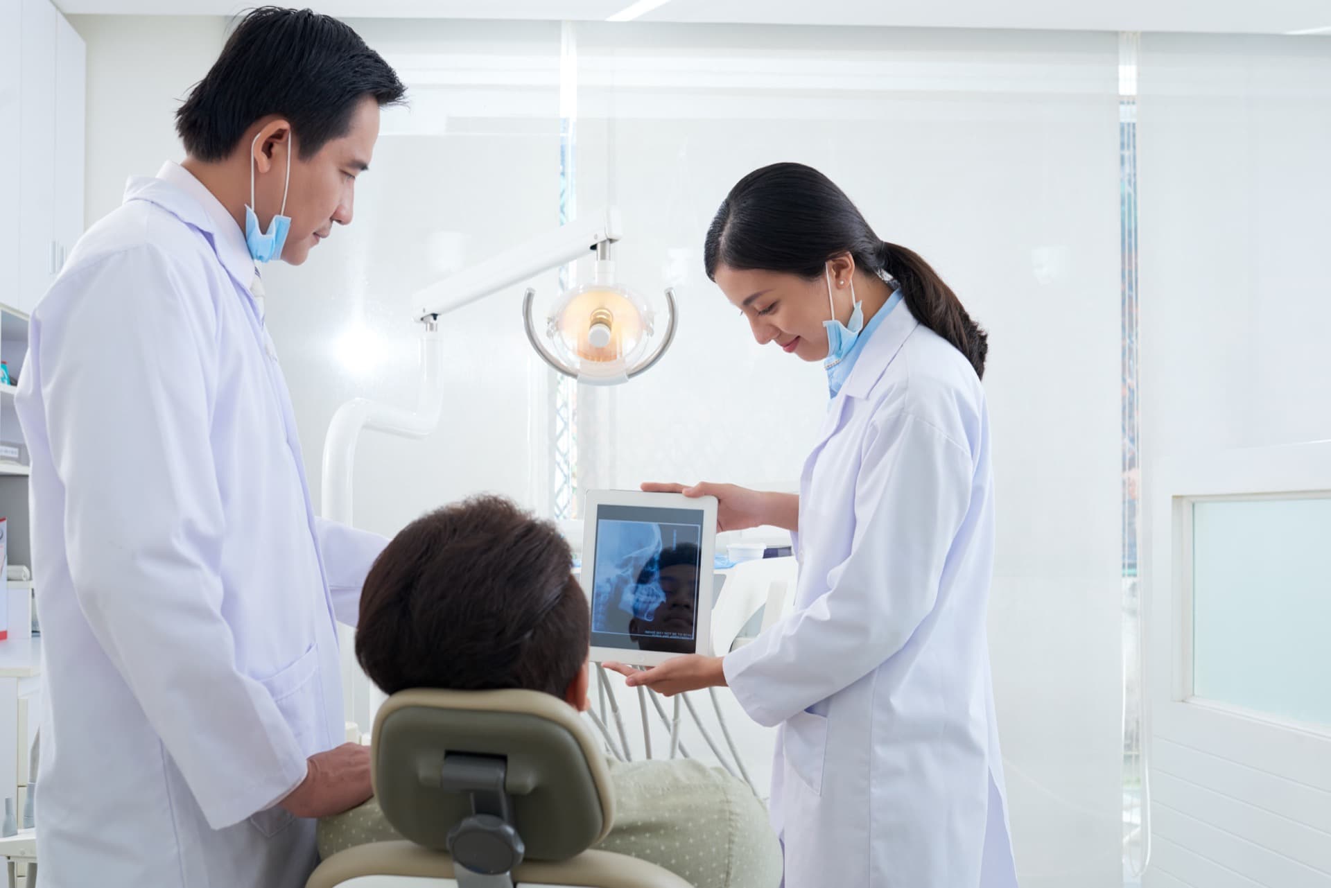 Dentist discussing a dental X-ray with a seated patient
